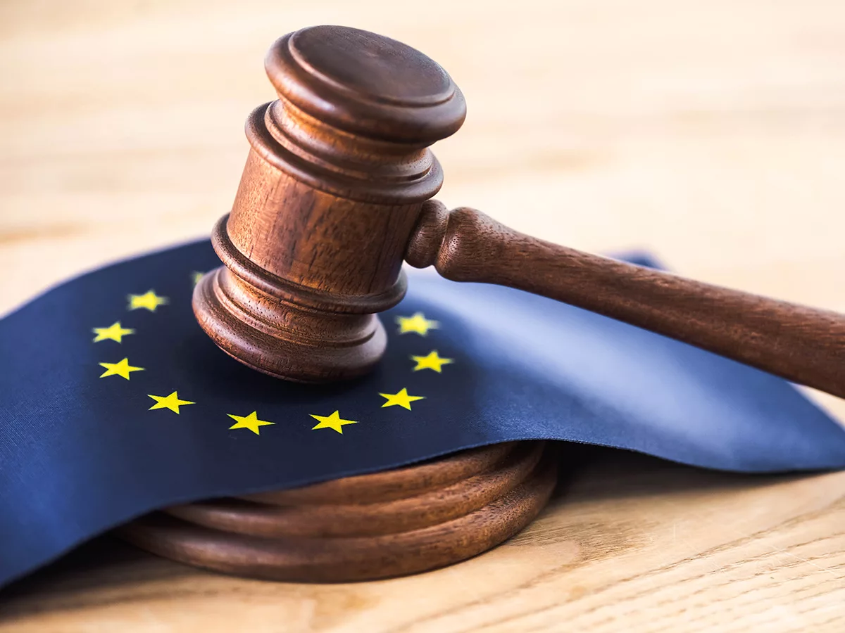Hammer auf einer Europaflagge - steht symbolisch für die neue EU-Verordnung zum Zahlungsverzug